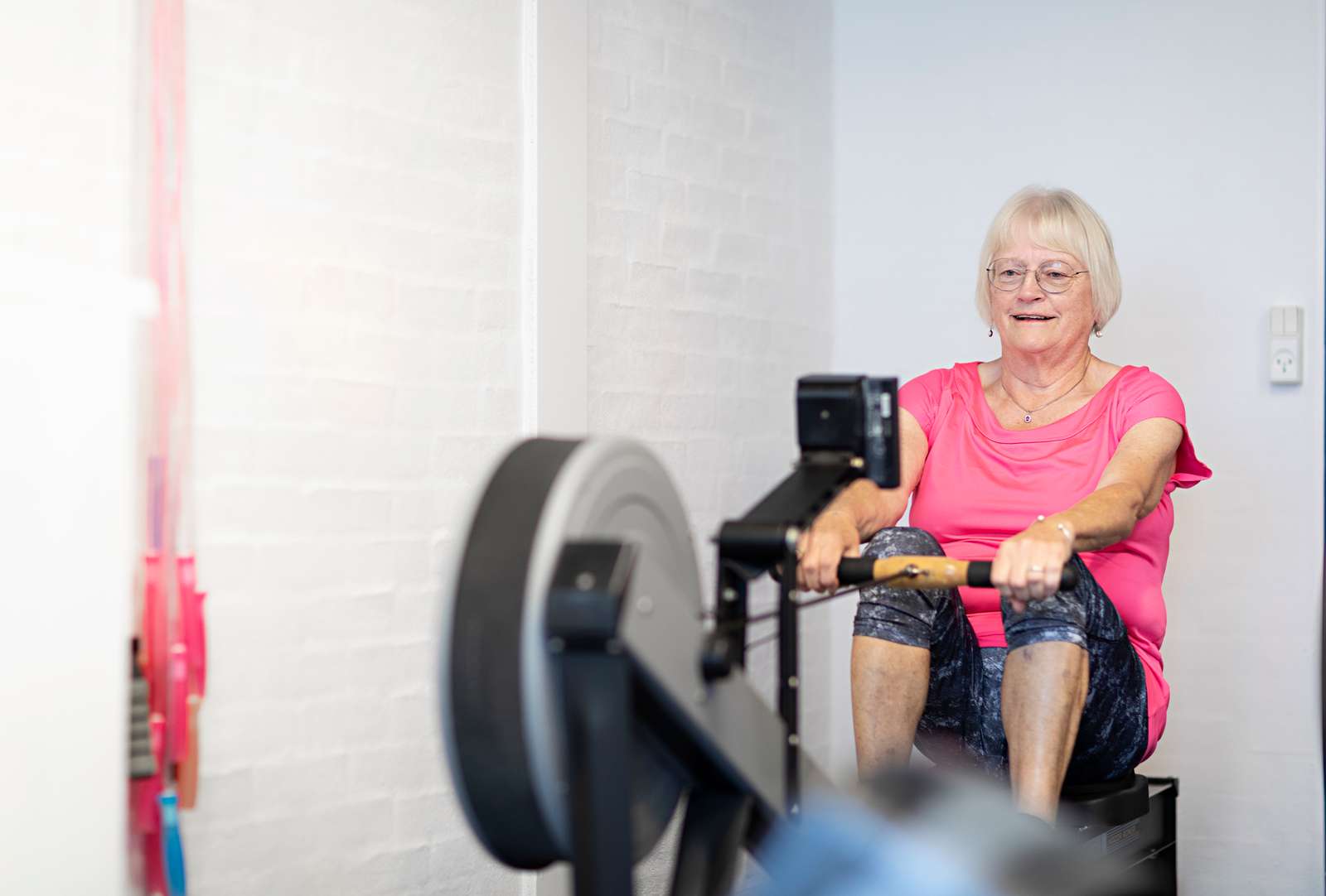 Billede af en kvinde, der træner i en romaskine.
